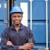 selective-focus-at-face-of-black-african-logistic-worker-wearing-safety-equipment-check-and-inspection-the-condition-of-container-while-talking-and-communi